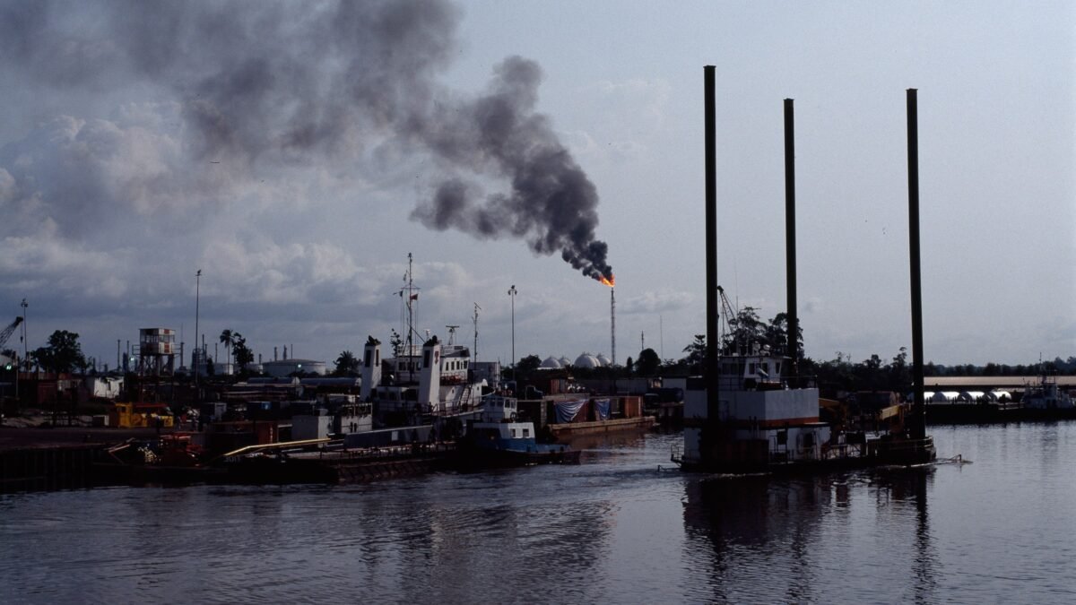 A burning gas flare and black smoke over Nembe Creek, Niger Delta, Nigeria.