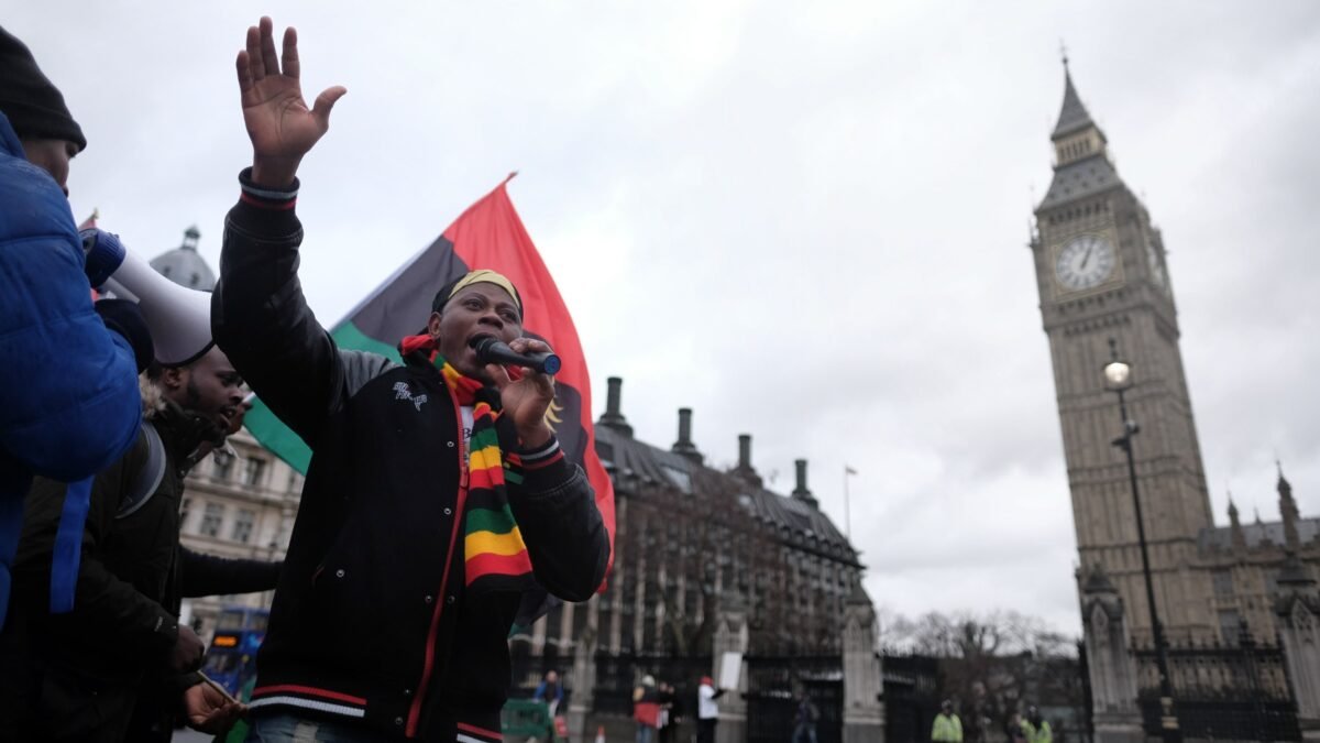 A demonstrator with a Biafran flag outside the Palace of Westminster, London.
