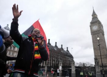 A demonstrator with a Biafran flag outside the Palace of Westminster, London.