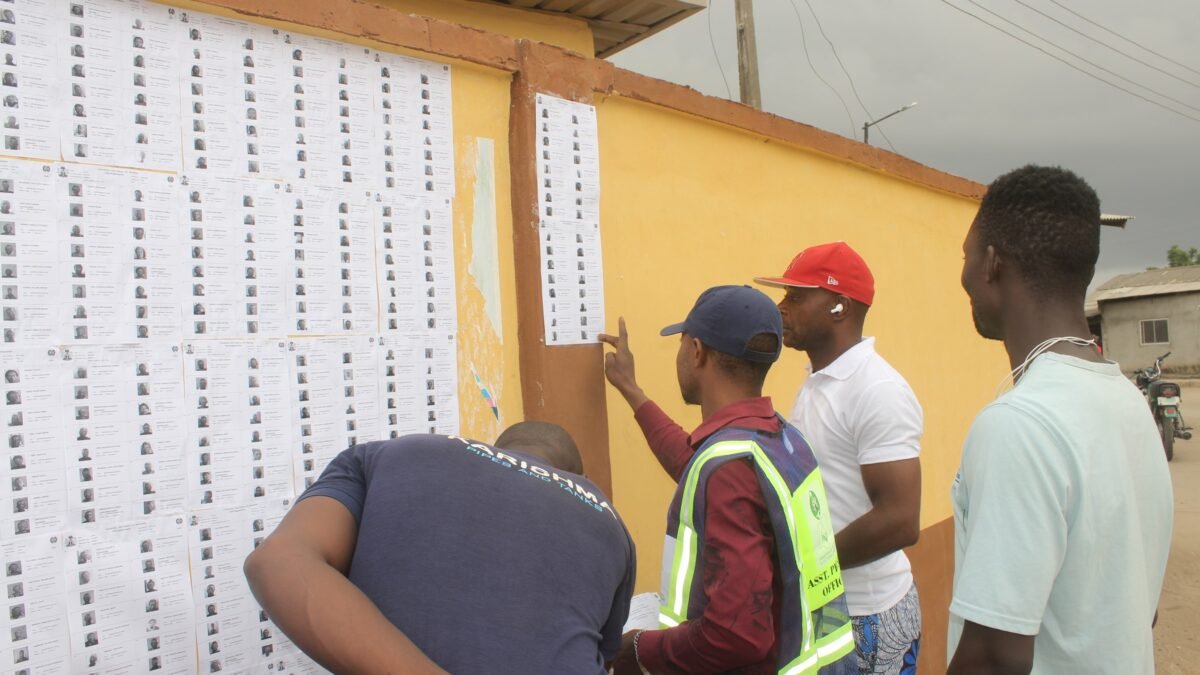 Voters checking their names on register sheets posted on a wall during Nigeria's 2023 elections.