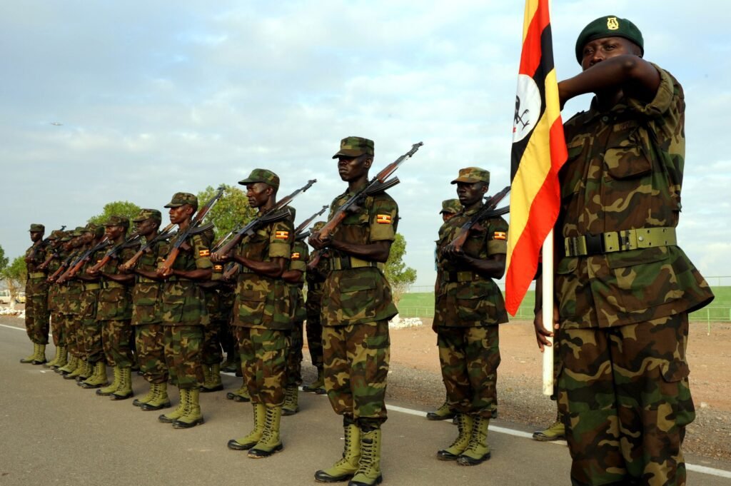 Ugandan soldiers on parade with the national flag.