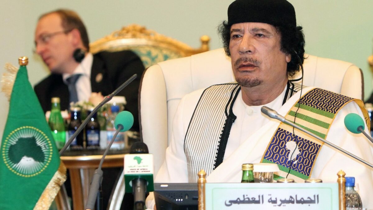 Muammar Gaddafi seated beneath an African Union flag in 2010.