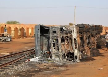 Traffic passing the wreckage of a burnt-out tanker in Niamey, Niger.