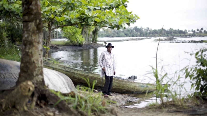 A man standing beside a polluted creek in the Goi community, Ogoniland, Nigeria.