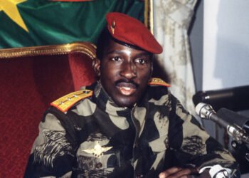 Thomas Sankara in a red beret and military fatigues at a press conference.