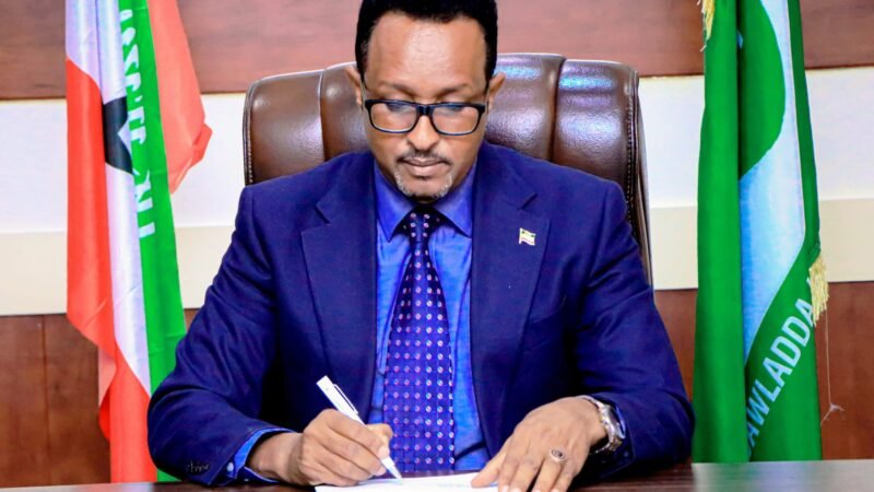 A Somaliland official at his desk between national flags.