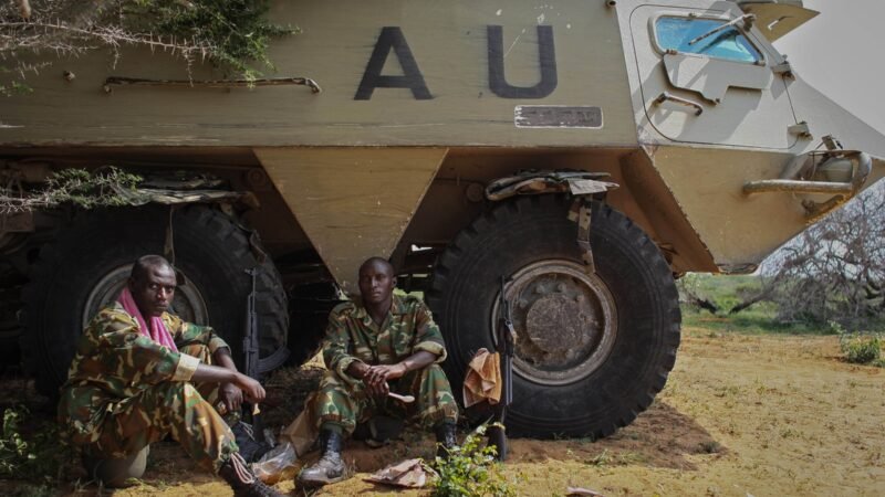 Soldiers resting beside an African Union armoured vehicle in Somalia.