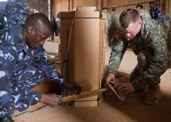 A US soldier and a member of the Mali Air Force loading cargo at Mopti airfield, Sevare.