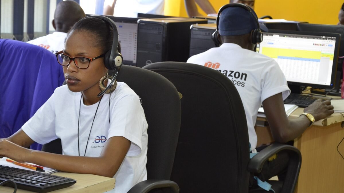 A woman working at a headset and screen in an outsourced service centre in Africa.